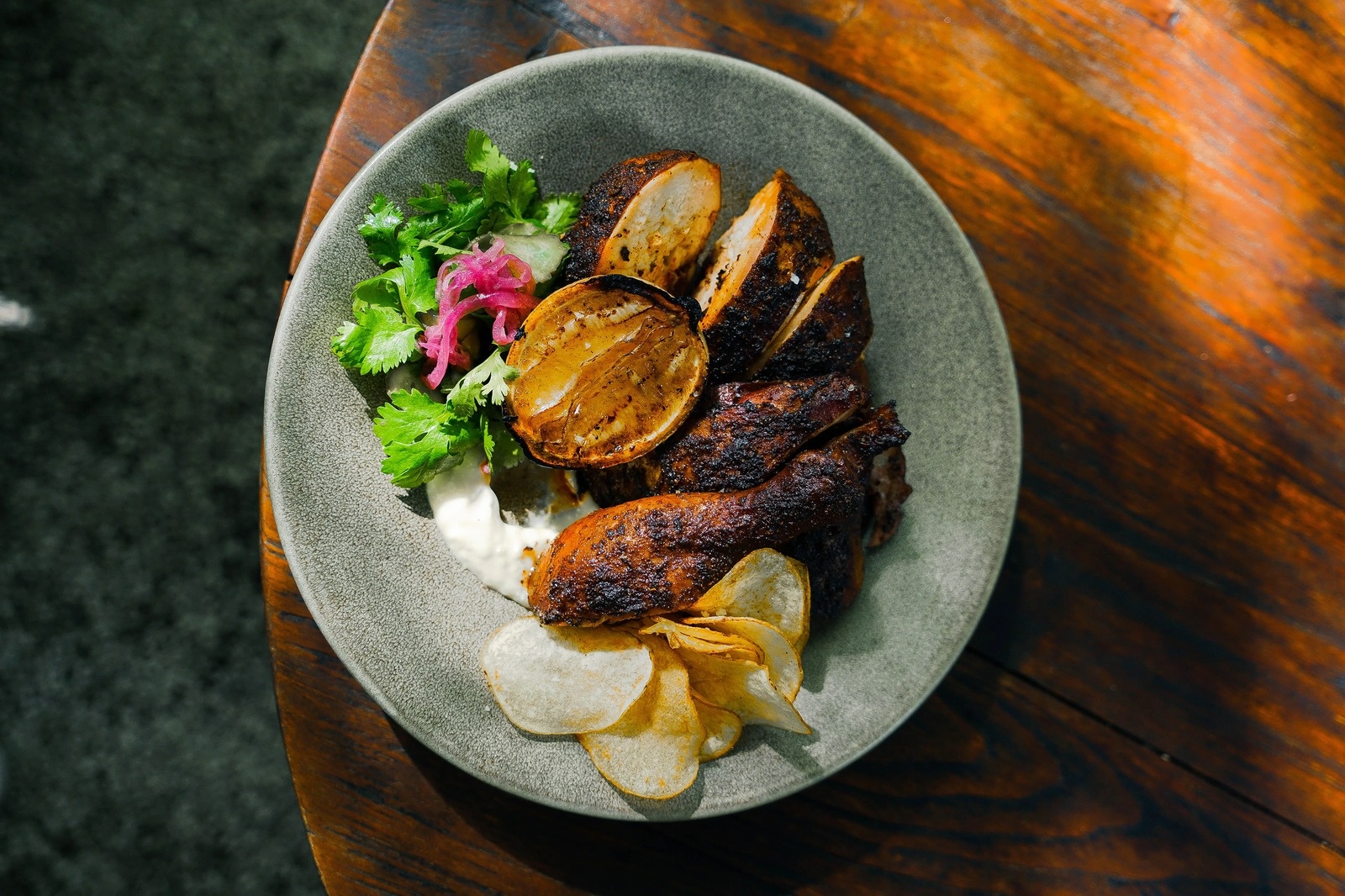 A charred chicken dish with pickles and greens at Shelter