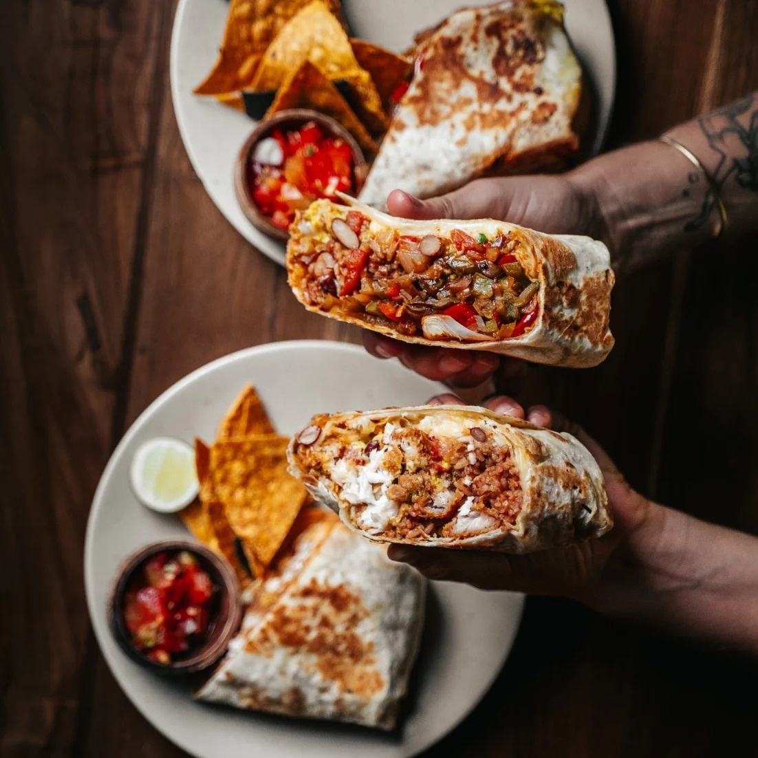 Burritos cut in half with corn chips and salsa at Lola’s Cantina Mexicana