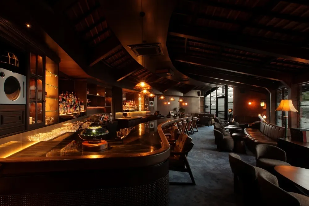 Booths, armchairs and the long curved bar at AOKU.