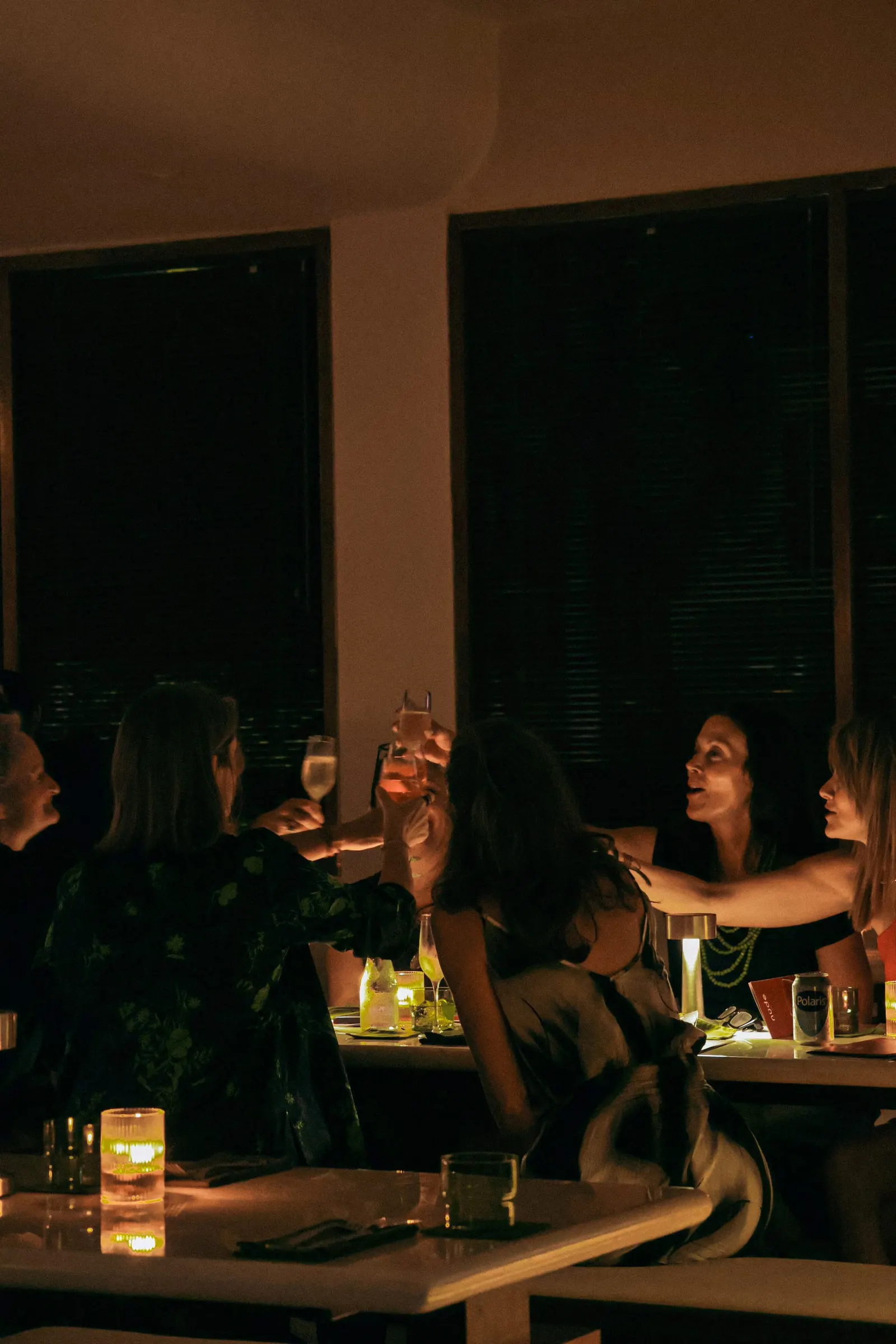 Guests laughing over cocktails and wine inside the new nüde Berawa dinner venue in Canggu, Bali.