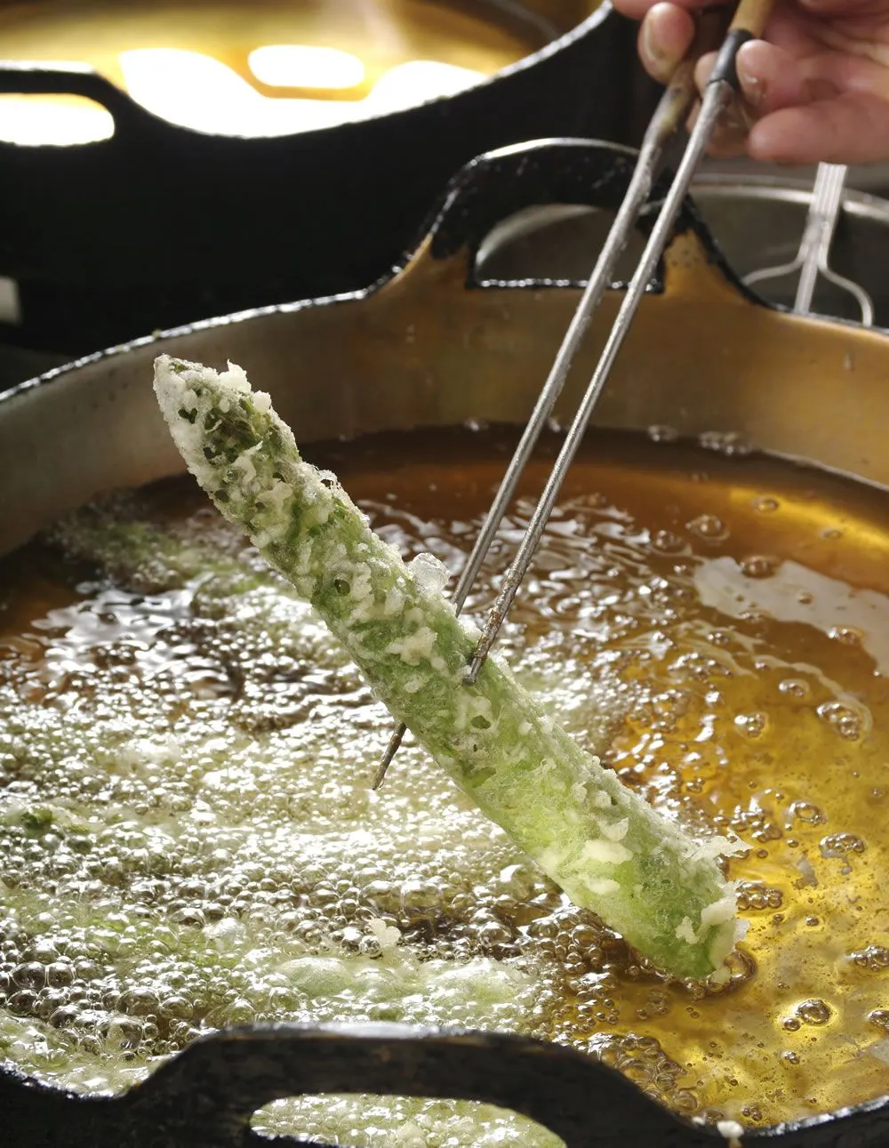 Asparagus being fried in the tempura pot at Tempura Kondo